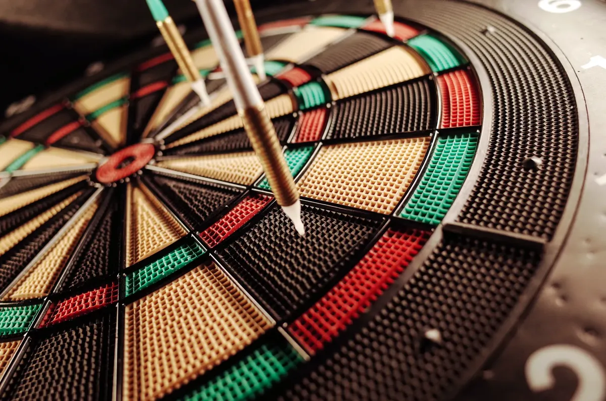 A detailed close-up of an electronic dartboard, showcasing vibrant colors and precision darts hitting the target.